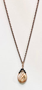 This handmade Scolecite pendant is wrapped in warm copper and accented with faceted black Onyx beads for bold contrast. A one-of-a-kind gemstone necklace combining peace and strength.
