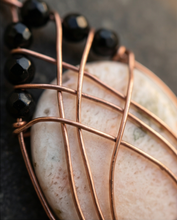 Load image into Gallery viewer, Handmade Scolecite pendant is wrapped in warm copper and accented with faceted black Onyx beads for bold contrast. A one-of-a-kind gemstone necklace combining peace and strength.