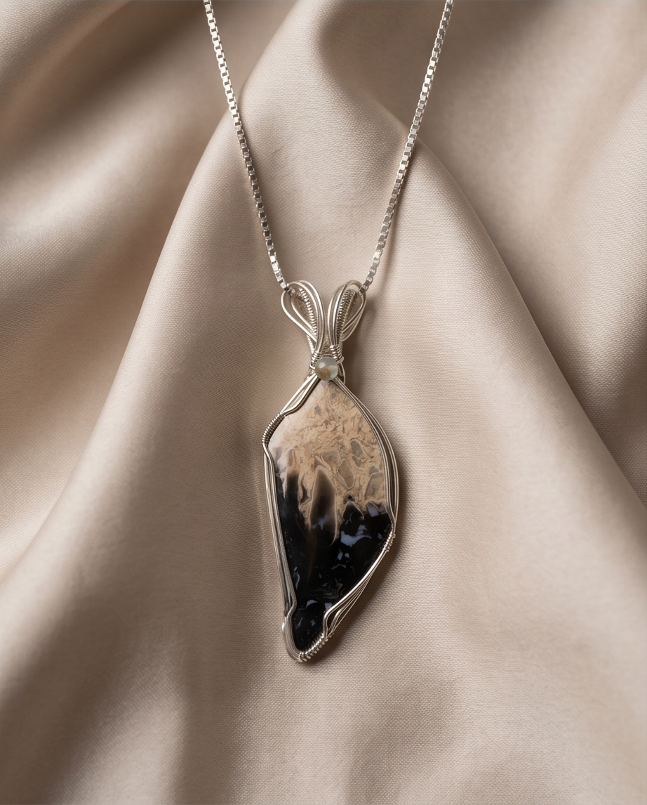 Heart shaped Palm Root stone pendant set in sterling silver featuring natural fossilized patterns.