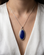 Load image into Gallery viewer, Oval Lapis Lazuli pendant set in handcrafted sterling silver with decorative bezel detailing.
