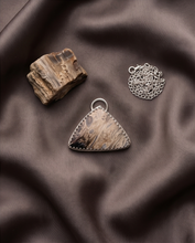 Load image into Gallery viewer, Lifestyle image of handcrafted sterling silver Palm Root pendant featuring natural fossil patterns and earth-tone petrified wood markings
