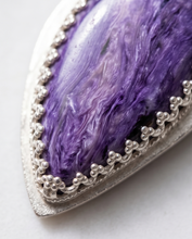 Load image into Gallery viewer, Lifestyle image of handcrafted sterling silver Charoite teardrop pendant featuring natural lavender and violet gemstone patterns
