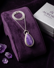 Load image into Gallery viewer, Lifestyle image of handcrafted sterling silver Charoite teardrop pendant featuring natural lavender and violet gemstone patterns
